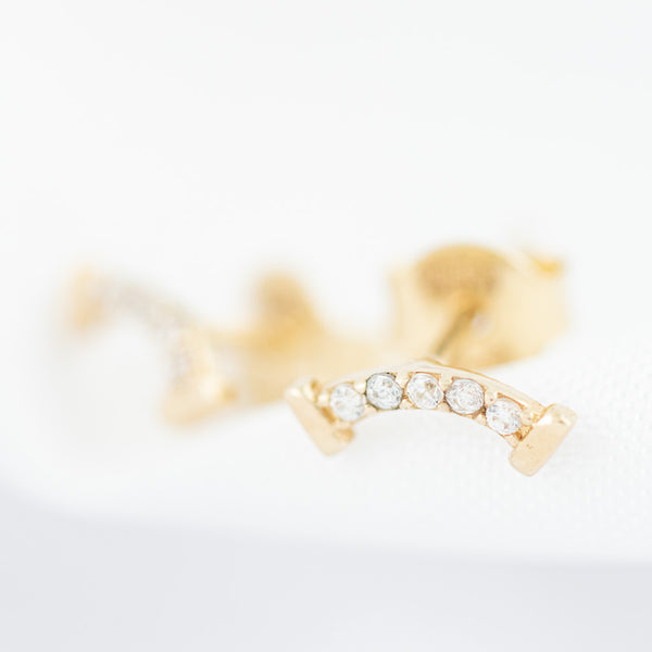Aretes estilizados con circonias en oro amarillo 14 kilates.