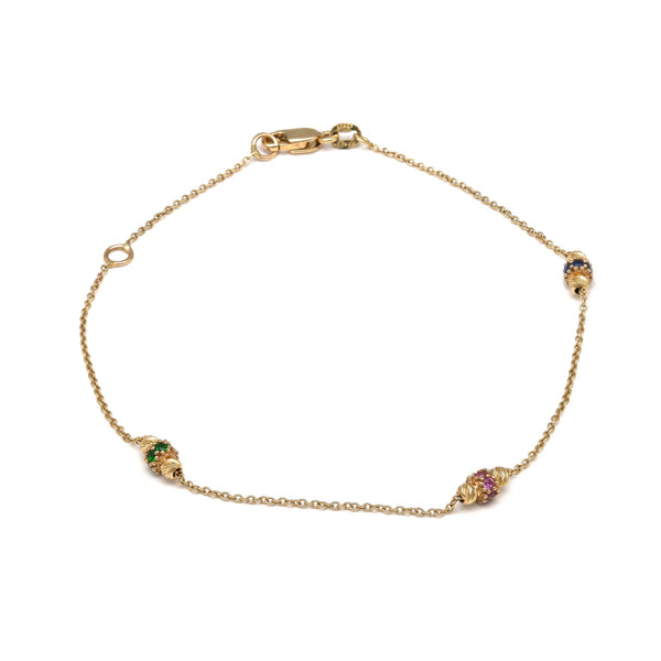 Pulsera eslabón cruzado con aplicaciones y sintéticos en oro amarillo 14 kilates.