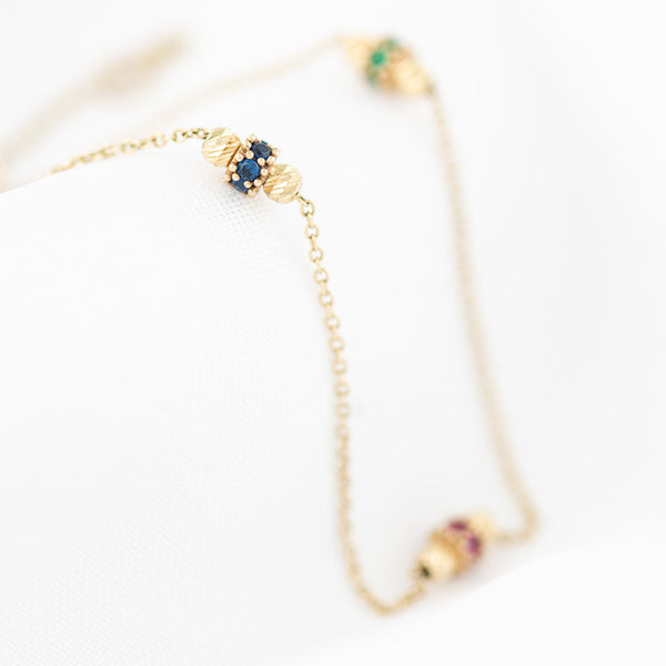 Pulsera eslabón cruzado con aplicaciones y sintéticos en oro amarillo 14 kilates.