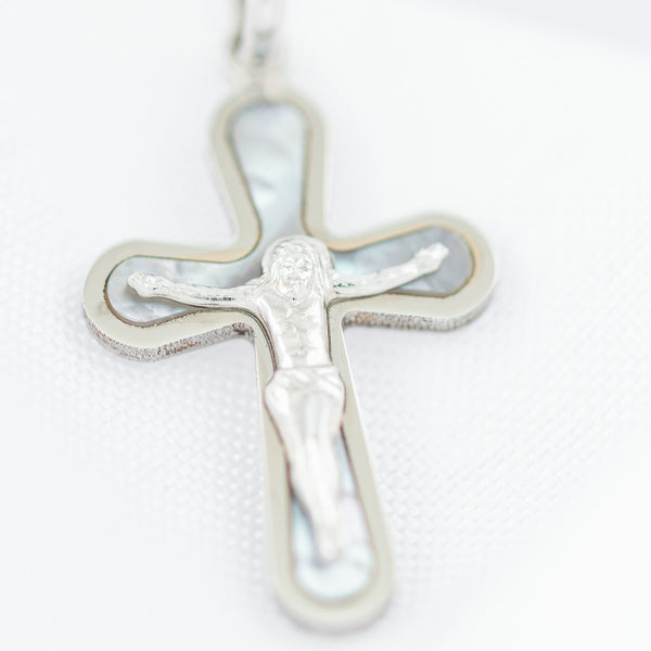 Crucifijo liso con madre perla en oro blanco 14 kilates.