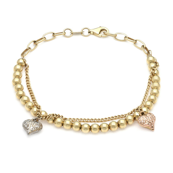 Pulsera eslabón combinado con aplicación y colgantes motivo esferas y corazón en oro amarillo 14 kilates.
