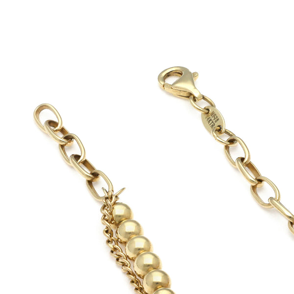 Pulsera eslabón combinado con aplicación y colgantes motivo esferas y corazón en oro amarillo 14 kilates.
