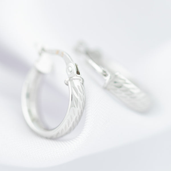 Arracadas martilladas huecas en oro blanco 14 kilates.