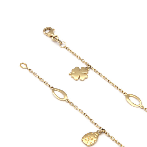 Pulsera eslabón cruzado con aplicaciones y colgantes en oro amarillo 14 kilates.