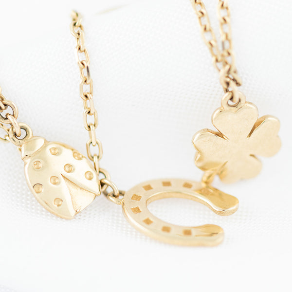 Pulsera eslabón cruzado con aplicaciones y colgantes en oro amarillo 14 kilates.