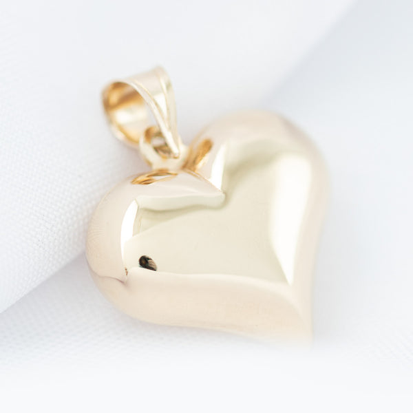 Dije hueco motivo corazón en oro amarillo 14 kilates.