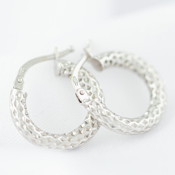 Arracadas martilladas huecas en oro blanco 14 kilates.