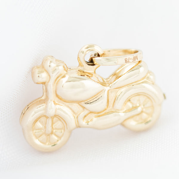 Dije hueco motivo motocicleta en oro amarillo 14 kilates.