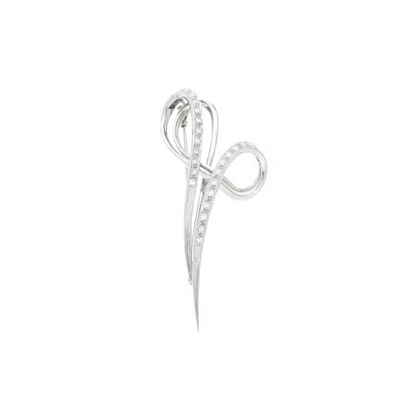 Prendedor estilizado con diamantes en oro blanco 14 kilates.