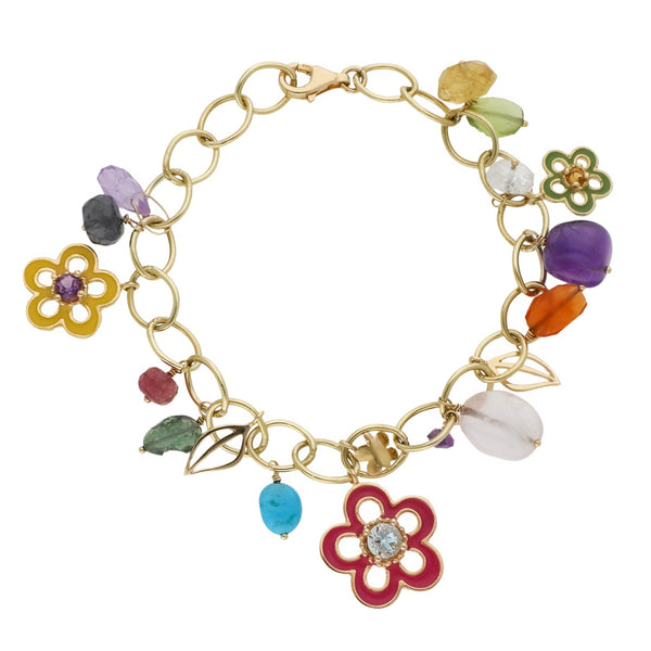 Pulsera eslabón cruzado con colgantes firma Tous motivo figuras diferentes y sintéticos en oro amarillo 18 kilates.