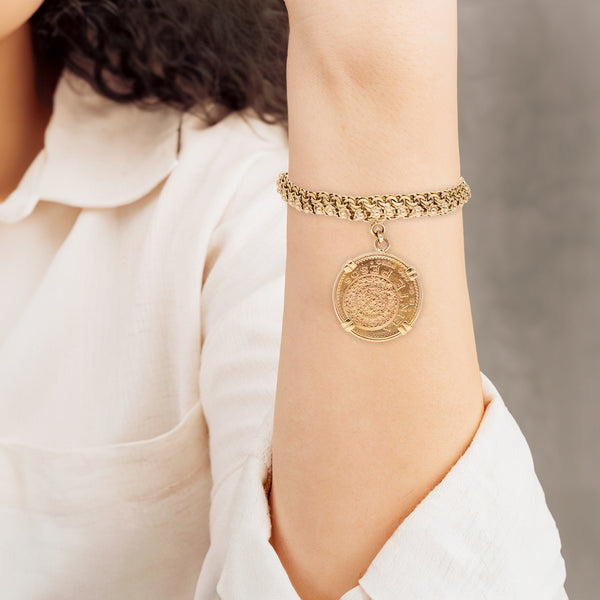 Pulsera eslabón tejido con aplicaciones y colgante con una moneda de veinte pesos oro mexicano 21.6 kilates en oro amarillo 18 kilates.