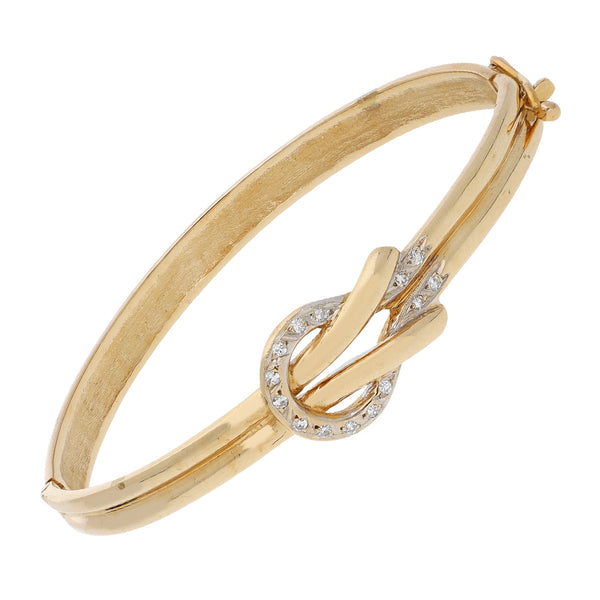 Pulsera de arillo articulada con aplicación motivo nudo y diamantes en oro amarillo 14 kilates.