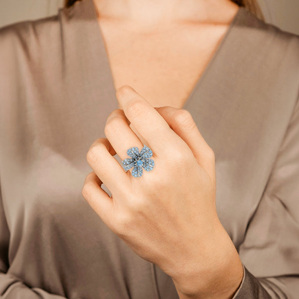 Juego de anillo y prendedor diseño especial motivo flor con sintéticos en oro blanco 18 kilates.