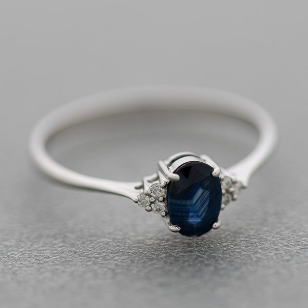 Anillo diseño especial con diamantes y zafiro en oro blanco 14 kilates.