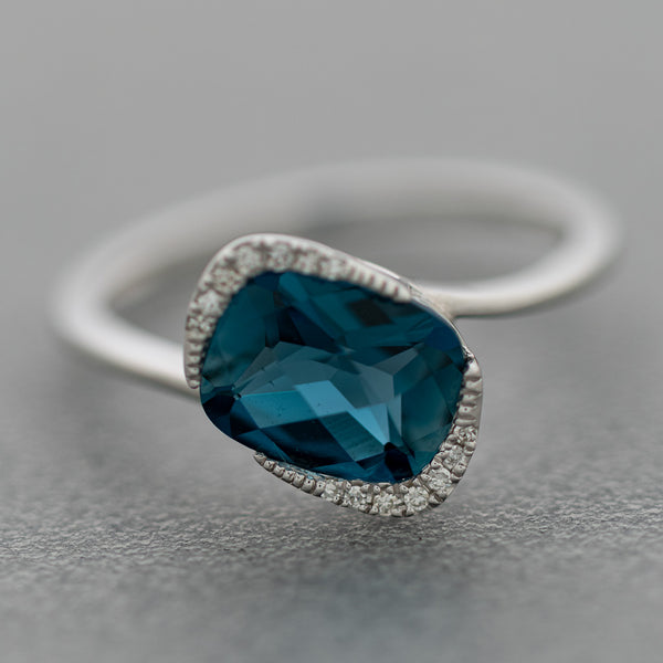 Anillo diseño especial con diamantes y topacio en oro blanco 14 kilates.