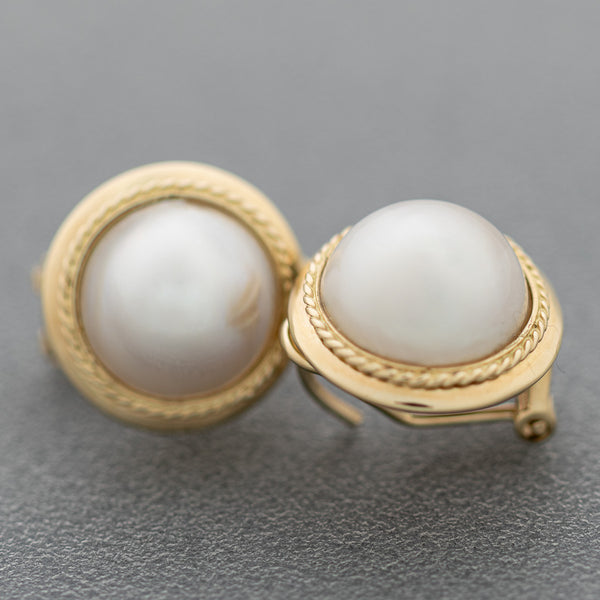 Aretes diseño especial con medias perlas en oro amarillo 14 kilates.