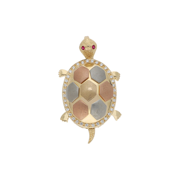 Dije diseño especial motivo tortuga con sintéticos en oro tres tonos.