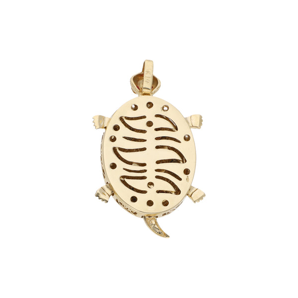 Dije diseño especial motivo tortuga con sintéticos en oro tres tonos.