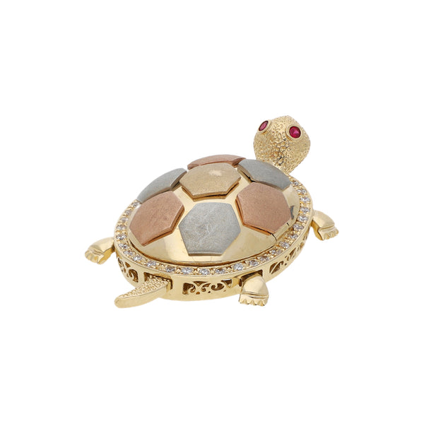 Dije diseño especial motivo tortuga con sintéticos en oro tres tonos.