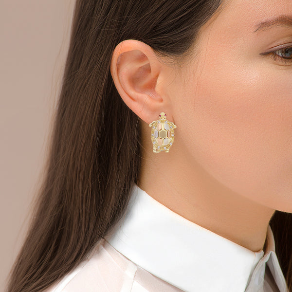 Aretes diseño articulado motivo tortuga con sintéticos en oro tres tonos 14 kilates.
