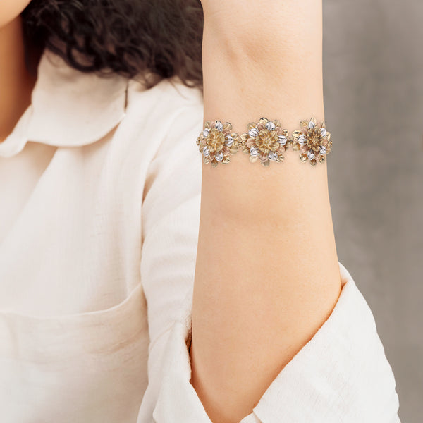 Pulsera eslabón laminado motivo flores en oro tres tonos 14 kilates.