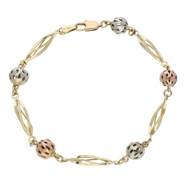 Pulsera eslabón combinado con aplicaciones motivo esferas en oro tres tonos 14 kilates.