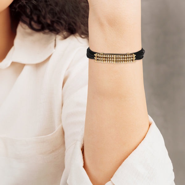 Pulsera textil con aplicaciones casquillos y broche con perlas en oro amarillo 14 kilates.