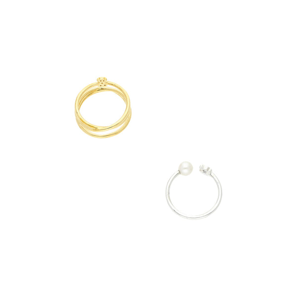 Dos anillos lisos firma Tous con diamantes y perla en oro blanco y amarillo 18 kilates.