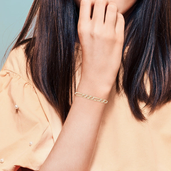Pulsera infantil de tres eslabones platinados por uno en oro amarillo 14 kilates.