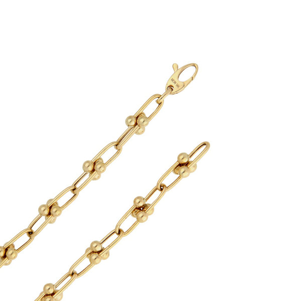 Juego de gargantilla y pulsera eslabón cruzado con aplicaciones en oro amarillo 14 kilates.