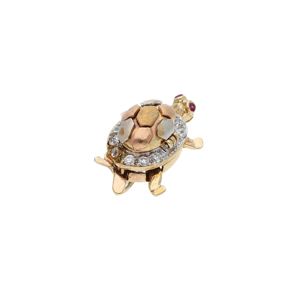Prendedor diseño especial motivo tortuga con sintéticos en oro tres tonos 14 kilates.