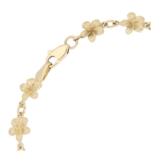 Pulsera eslabón cruzado con aplicaciones motivo flor en oro amarillo 14 kilates.