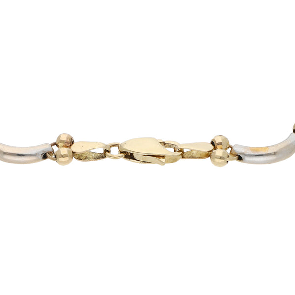Pulsera eslabón combinado con aplicación motivo esferas en oro dos tonos 14 kilates.