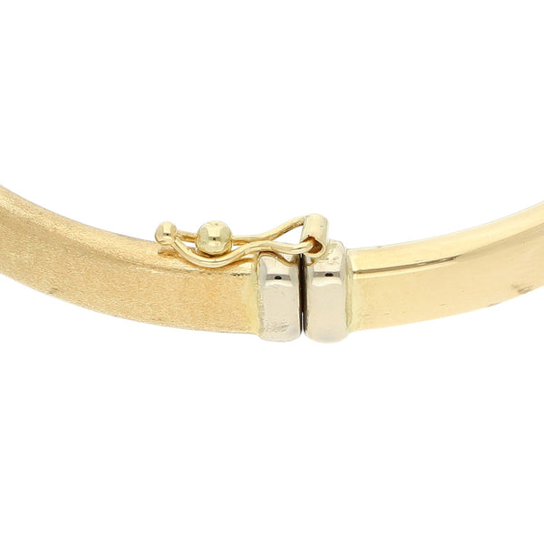 Pulsera de arillo articulada con aplicaciones en oro dos tonos 18 kilates.
