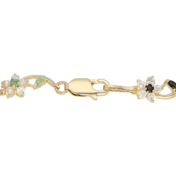 Pulsera eslabón articulado con aplicaciones de flores y sintéticos en oro amarillo 14 kilates.