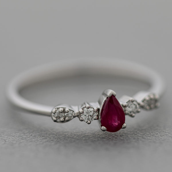 Anillo diseño especial con diamantes y rubí en oro blanco 14 kilates.