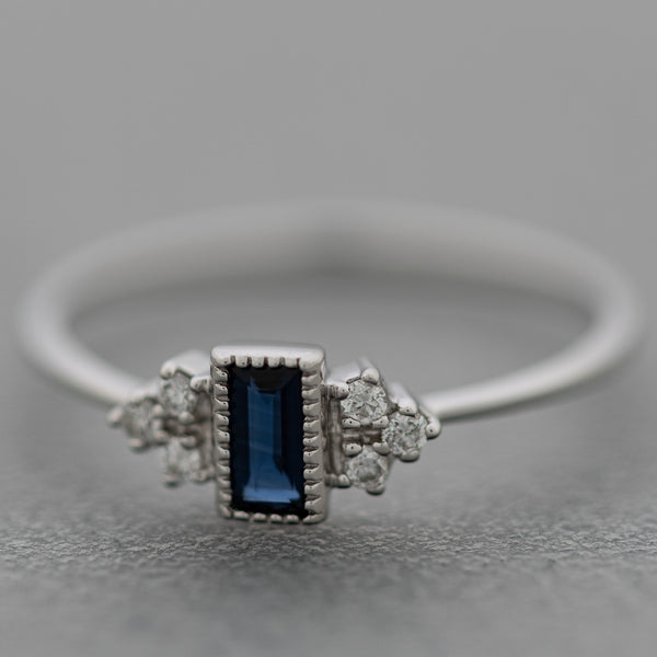Anillo diseño especial con diamantes y zafiro en oro blanco 14 kilates.