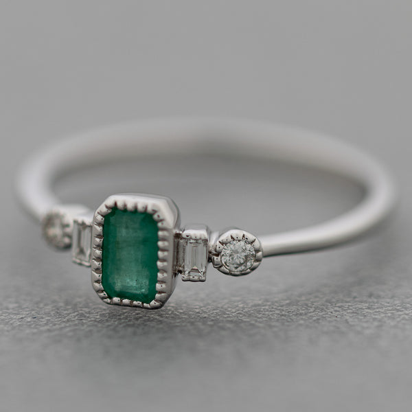 Anillo diseño especial con diamantes y esmeralda en oro blanco 14 kilates.