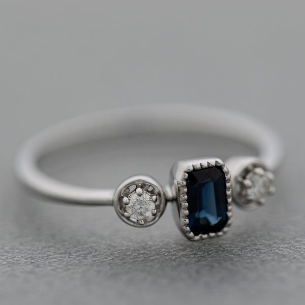 Anillo diseño especial con diamantes y zafiro en oro blanco 14 kilates.