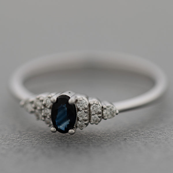 Anillo diseño especial con diamantes y zafiro en oro blanco 14 kilates.