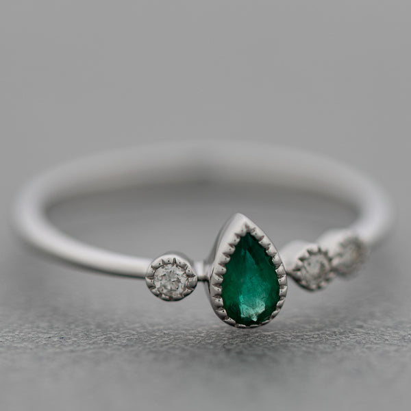 Anillo diseño especial con diamantes y esmeralda en oro blanco 14 kilates.