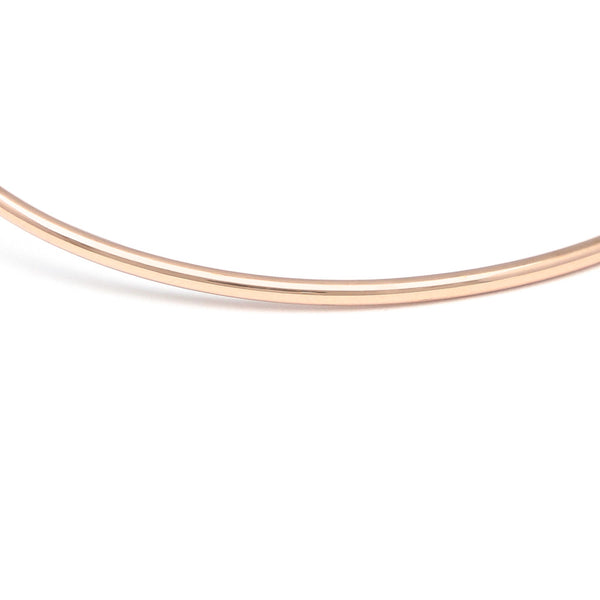Pulsera de arillo abierta motivo cruz y corazón con diamantes en oro rosa 14 kilates.