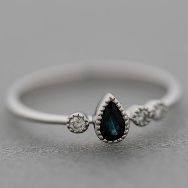 Anillo diseño especial con diamantes y zafiro en oro blanco 14 kilates.