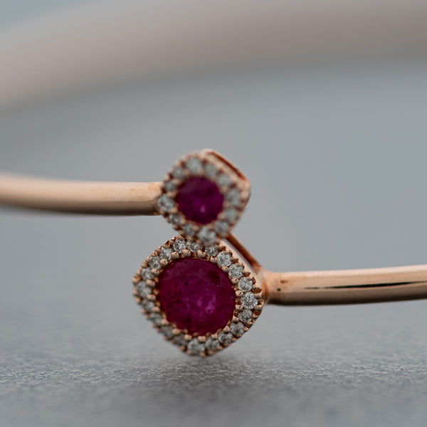 Pulsera de arillo abierta motivo rombos con diamantes y rubíes en oro rosa 14 kilates.