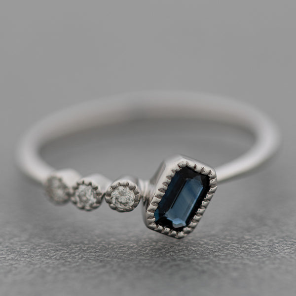 Anillo diseño especial con diamantes y zafiro en oro blanco 14 kilates.
