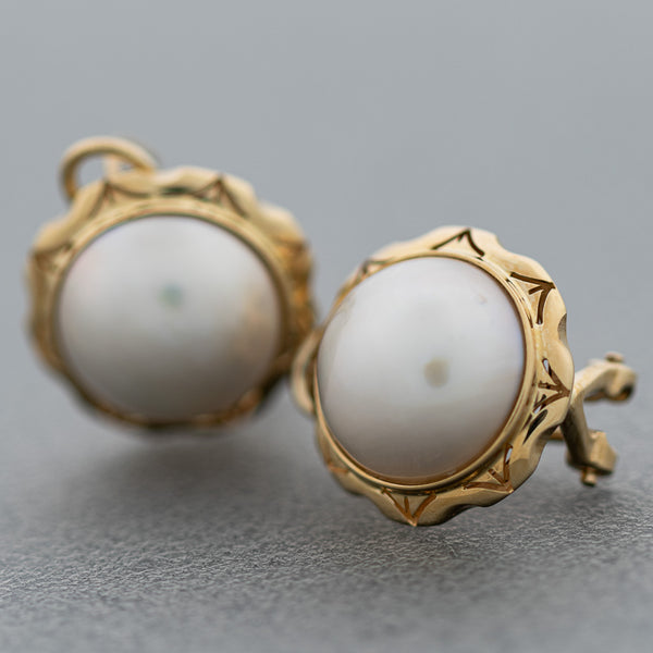 Aretes calados con media perla en oro amarillo 14 kilates.