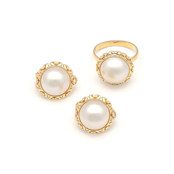 Juego de anillo y aretes calados con media perla en oro amarillo 14 kilates.