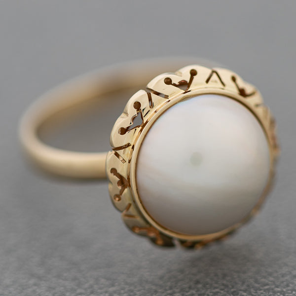 Juego de anillo y aretes calados con media perla en oro amarillo 14 kilates.