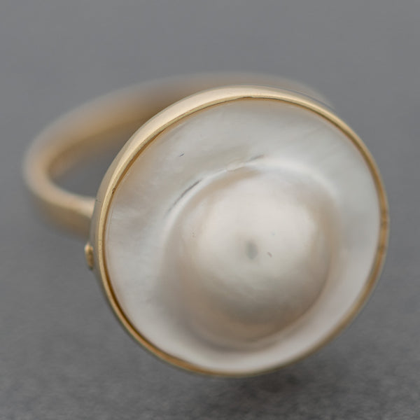 Juego anillo y aretes diseño especial con media perla en oro amarillo 14 kilates.