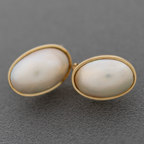 Aretes lisos con media perla en oro amarillo 14 kilates.